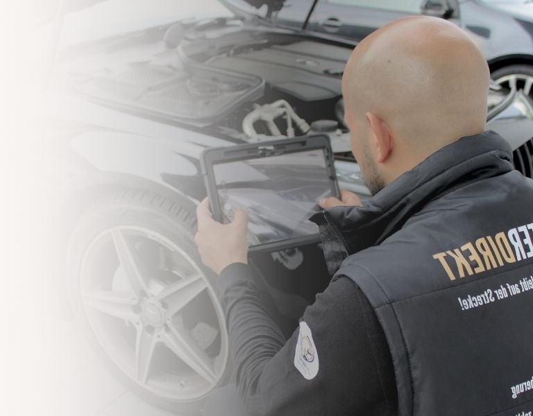 Kfz-Gutachter bei der Begutachtung eines Unfallfahrzeugs