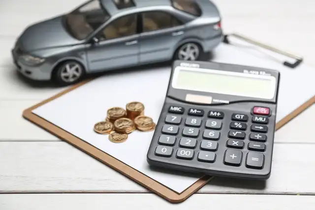 Taschenrechner und Geld symbolisieren die Entschädigung nach einem Verkehrsunfall